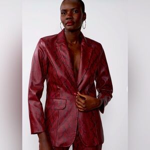 Saunter into the room commanding attention. Slip on faux snakeskin blazer.